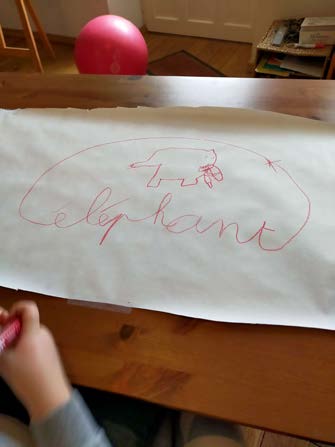 Le mot « éléphant » tracé en grand au feutre sur une large feuille de papier.